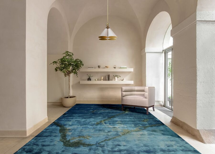 modern hallway with blue rug and neutral armchair